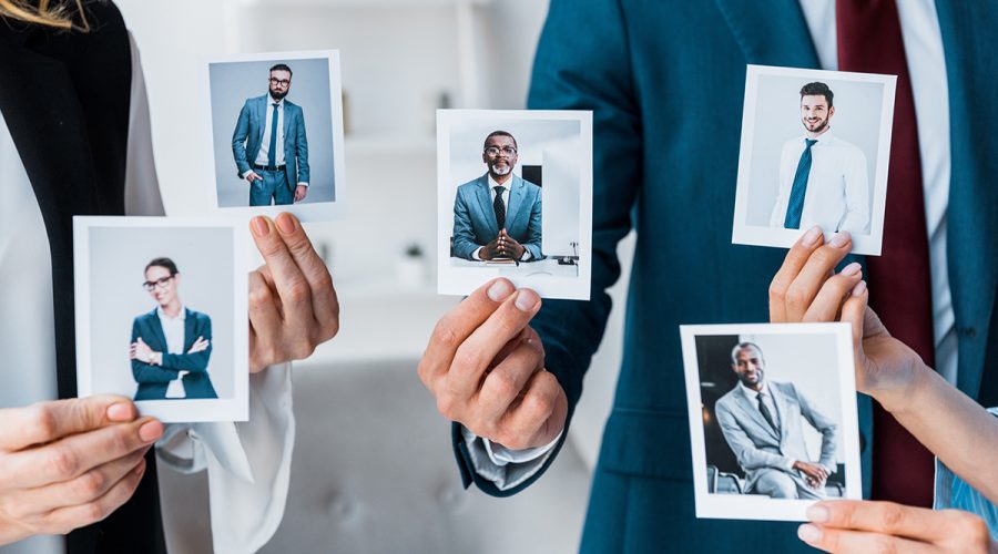 cropped view of recruiters touching photos while standing in office